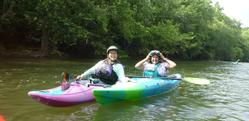 Two lady kayakers... Melissa on left as Guide with beacon and Candy on right wearing VibroGuide vest.